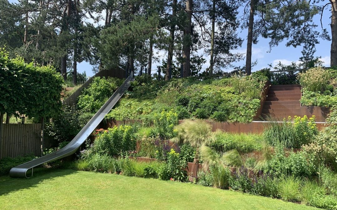 raised flowerbeds leading up an embankment with metal slide