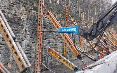 Platipus Skinnerburn Road0 earth anchor being driven through retaining wall with props